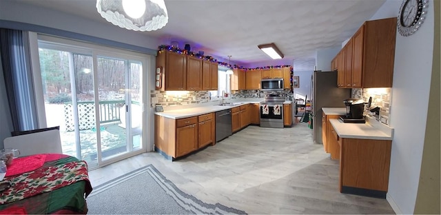 kitchen with appliances with stainless steel finishes, backsplash, and plenty of natural light