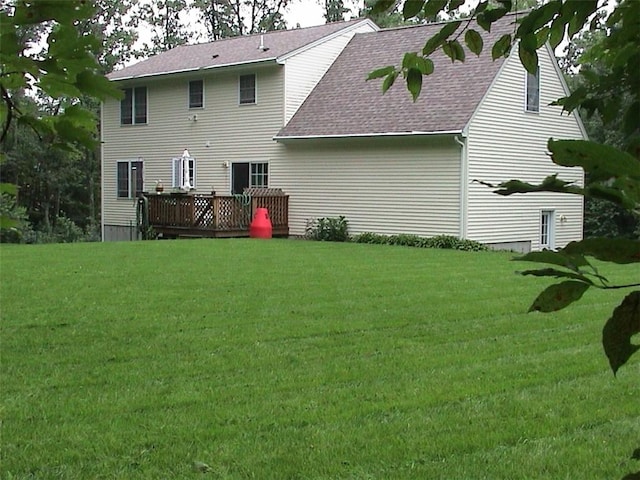 rear view of property with a lawn and a wooden deck