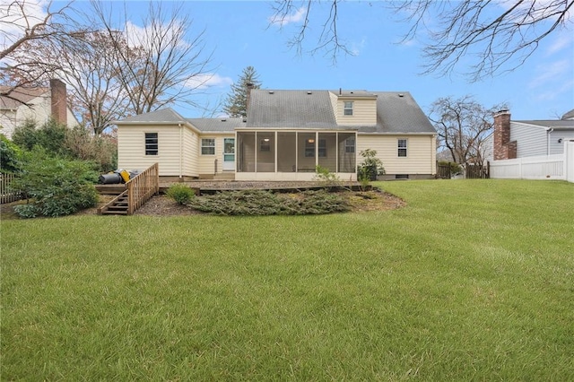 rear view of property with a sunroom and a yard