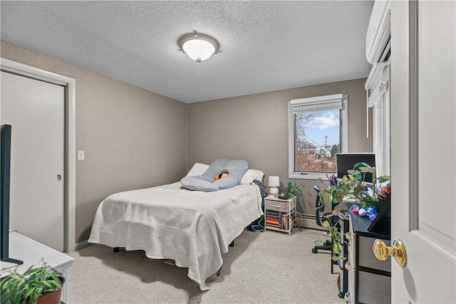 bedroom with carpet floors and a textured ceiling