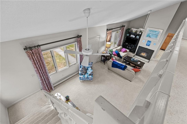 living room featuring carpet floors, a baseboard radiator, and vaulted ceiling