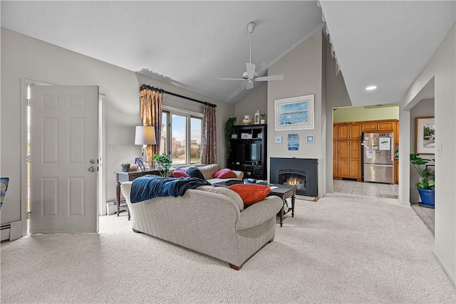 living room featuring light colored carpet, vaulted ceiling, ceiling fan, and a baseboard heating unit