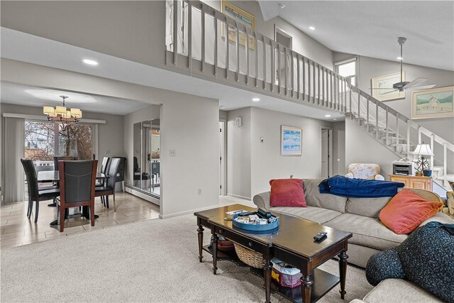 living room featuring light colored carpet, ceiling fan with notable chandelier, and a baseboard heating unit