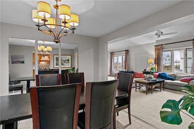 carpeted dining room featuring ceiling fan with notable chandelier