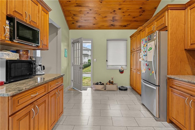 kitchen with stainless steel refrigerator, stone counters, wood ceiling, and vaulted ceiling