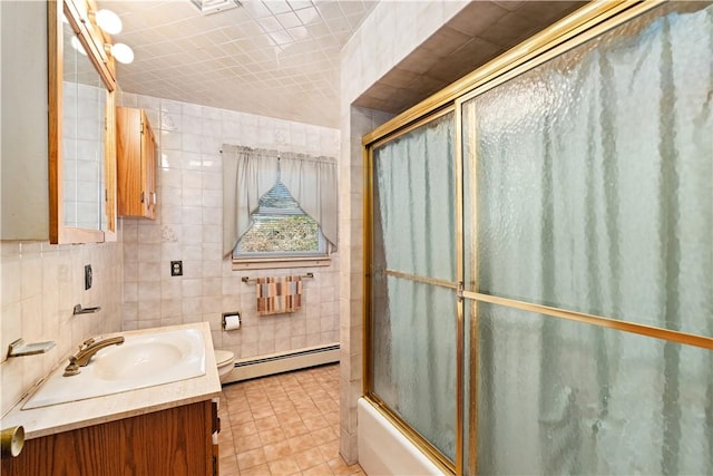 full bathroom with vanity, a baseboard radiator, tile patterned floors, and tile walls