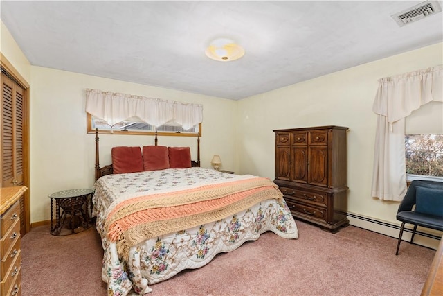 carpeted bedroom with baseboard heating and a closet