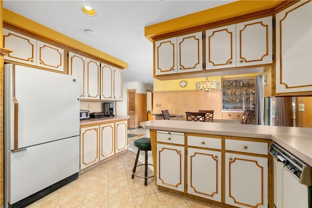 kitchen featuring kitchen peninsula, white appliances, light tile patterned flooring, and a breakfast bar