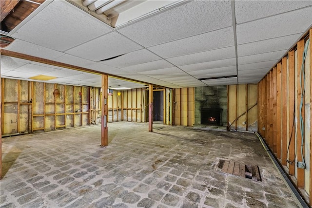 basement featuring a fireplace and a drop ceiling