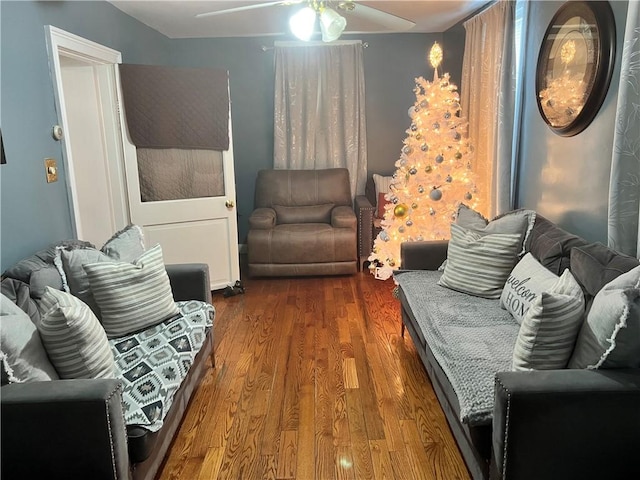 living room with dark hardwood / wood-style flooring and ceiling fan