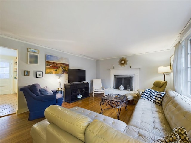 living room with crown molding, dark wood-type flooring, and a wealth of natural light