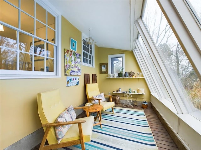 living area with plenty of natural light, hardwood / wood-style flooring, and vaulted ceiling