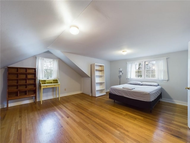 bedroom with lofted ceiling and wood-type flooring