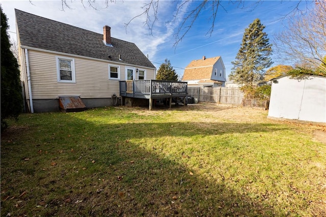 back of property with a yard and a deck