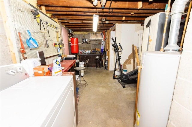 basement with a workshop area, washing machine and clothes dryer, and water heater