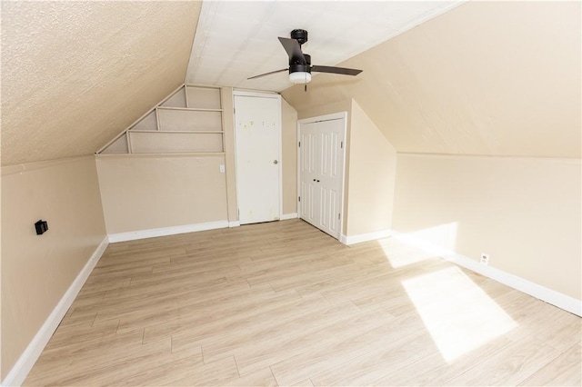 bonus room featuring a textured ceiling, ceiling fan, lofted ceiling, and light wood-type flooring