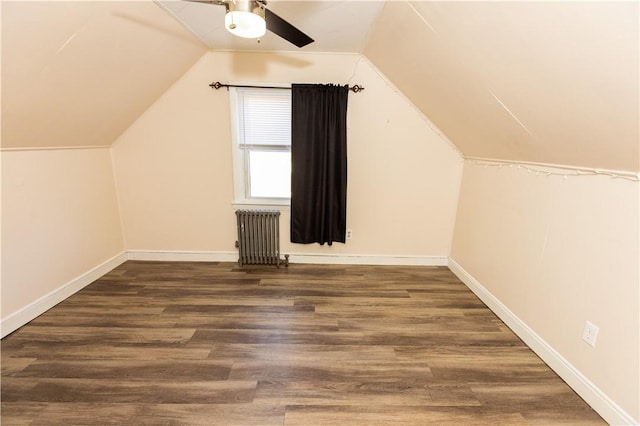 bonus room featuring ceiling fan, dark wood-type flooring, radiator, and vaulted ceiling