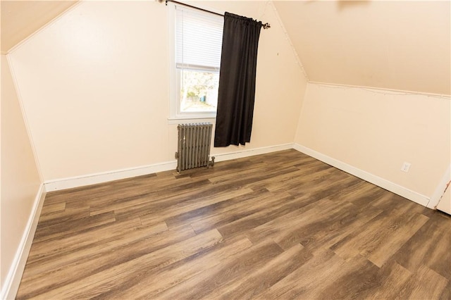 additional living space with hardwood / wood-style floors, radiator, and vaulted ceiling