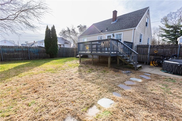 back of property featuring a lawn and a wooden deck