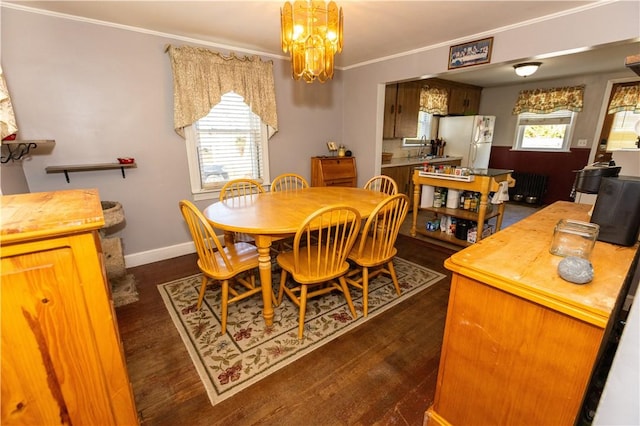 dining room with a notable chandelier, radiator heating unit, dark wood-type flooring, and ornamental molding