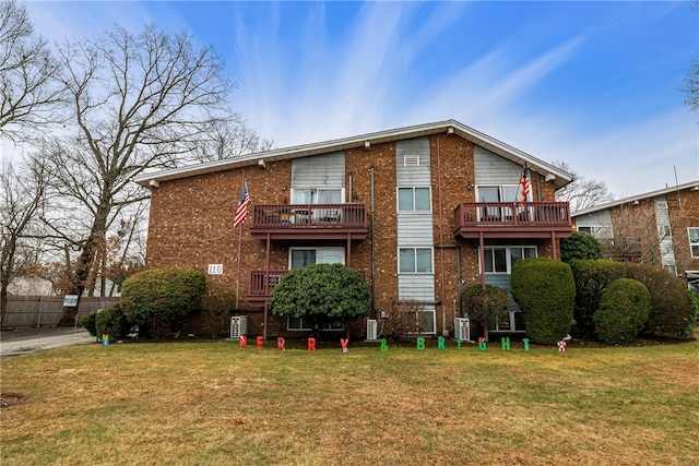 back of property featuring a lawn and a balcony