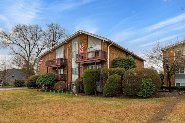 exterior space featuring a balcony and a front lawn