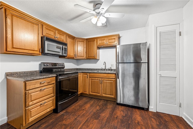 kitchen featuring sink, dark hardwood / wood-style floors, ceiling fan, a textured ceiling, and appliances with stainless steel finishes