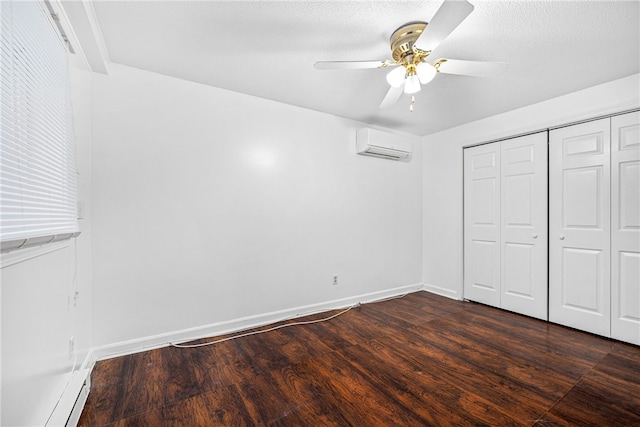 unfurnished bedroom featuring a wall mounted air conditioner, a textured ceiling, ceiling fan, dark wood-type flooring, and a closet