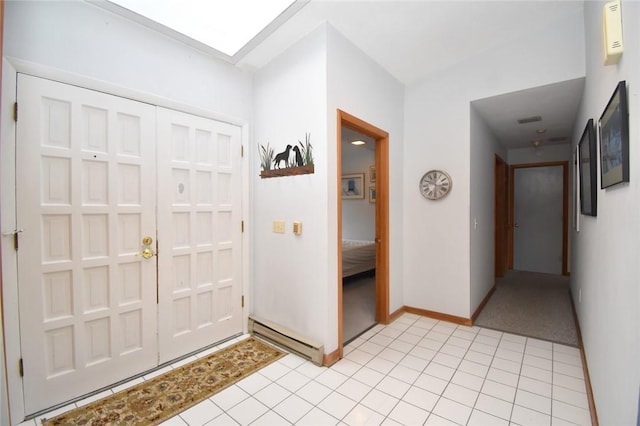 tiled foyer with a baseboard heating unit