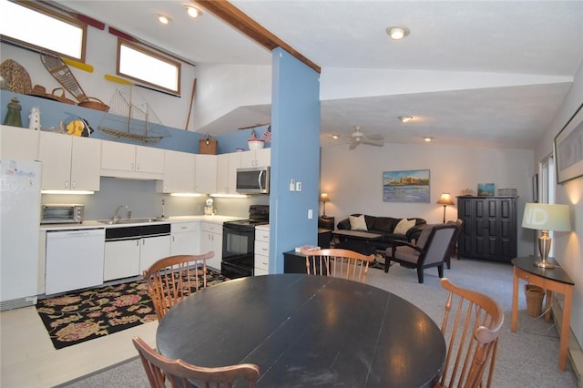 dining space featuring ceiling fan, sink, light colored carpet, and vaulted ceiling