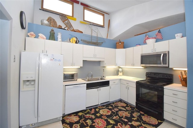 kitchen with white cabinetry, sink, and white appliances