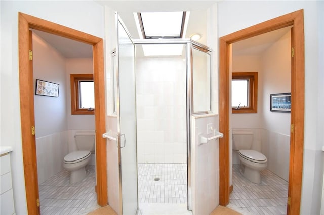 bathroom with tile patterned flooring, toilet, an enclosed shower, and tile walls