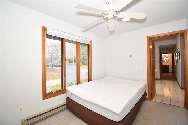 bedroom with ceiling fan, light colored carpet, and baseboard heating