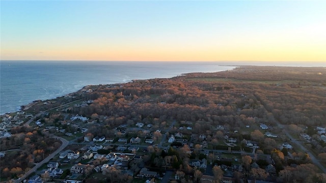 aerial view at dusk featuring a water view