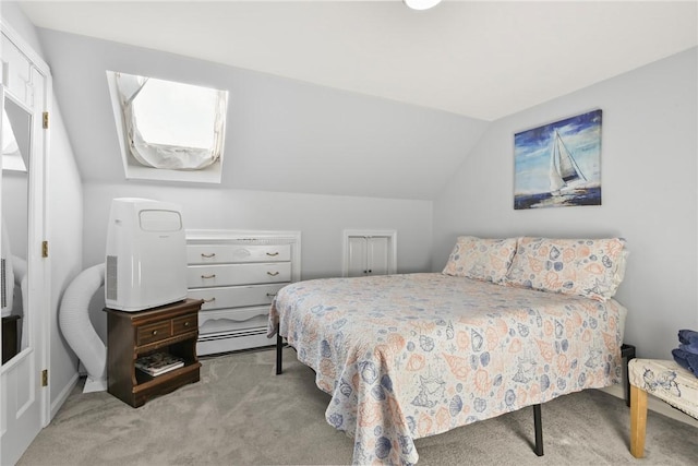 carpeted bedroom featuring vaulted ceiling and a baseboard heating unit