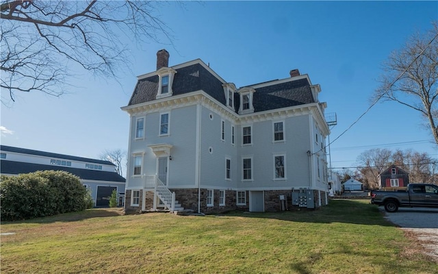 rear view of house featuring a yard