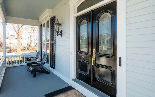 entrance to property featuring a porch and french doors