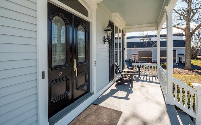 view of exterior entry with french doors and covered porch