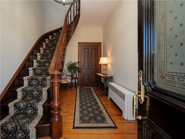 foyer with radiator heating unit and hardwood / wood-style floors