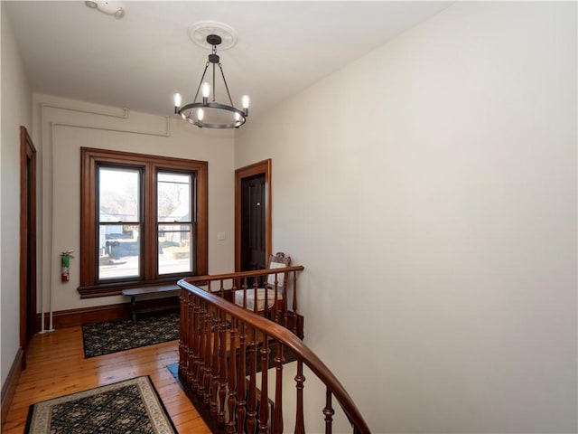 hallway with light hardwood / wood-style floors and a notable chandelier