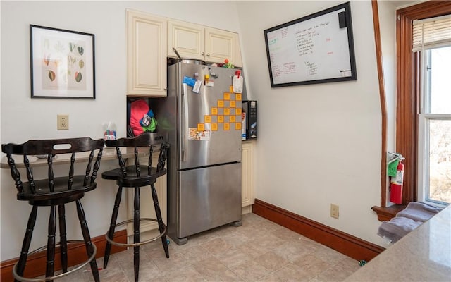 kitchen with stainless steel fridge and cream cabinets