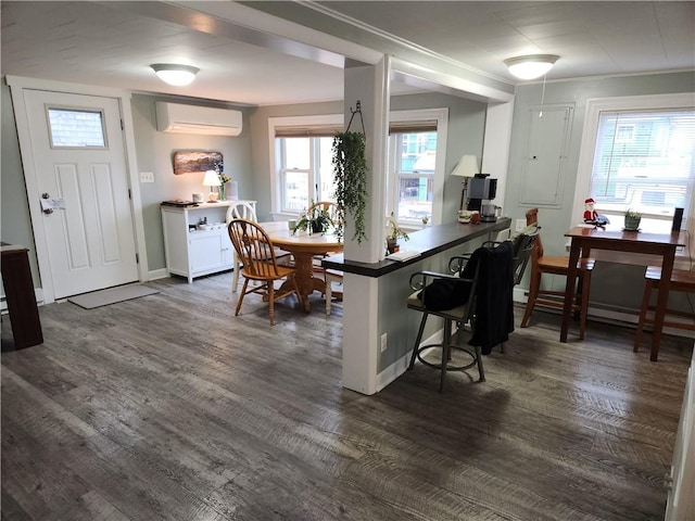 kitchen with white cabinetry, a wealth of natural light, dark wood-type flooring, a wall mounted AC, and a breakfast bar area