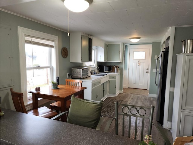 kitchen featuring light hardwood / wood-style floors, ornamental molding, sink, and appliances with stainless steel finishes