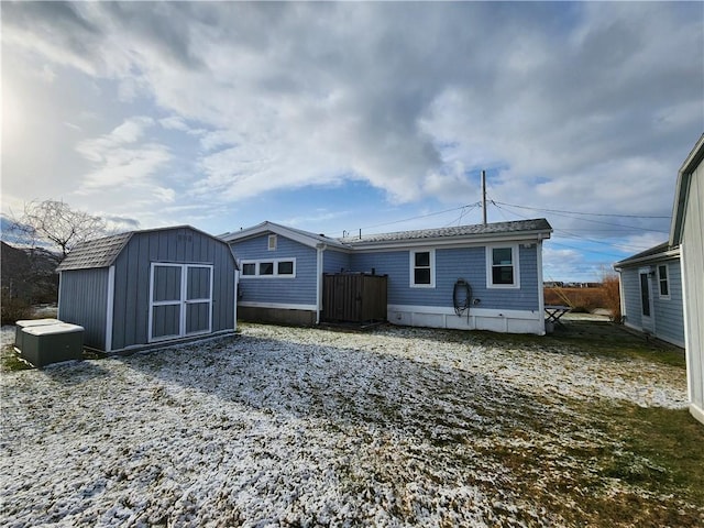 rear view of house with a storage unit and an outbuilding