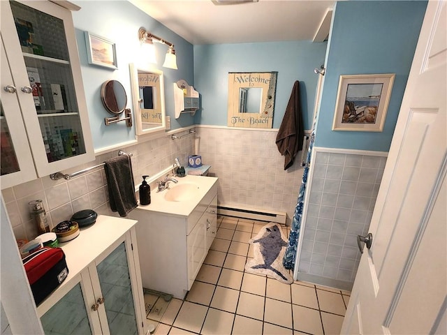 bathroom with baseboard heating, tile patterned flooring, vanity, and tile walls