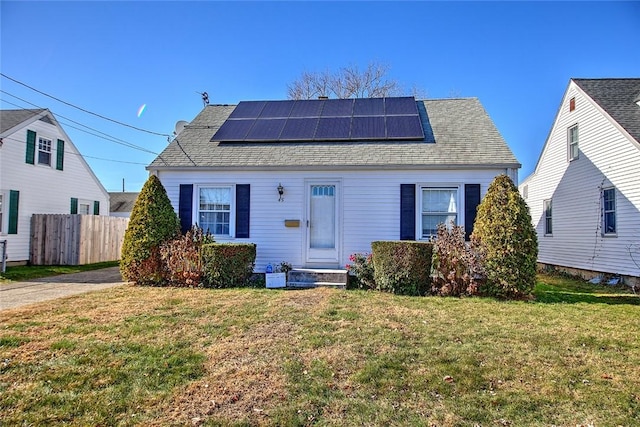 bungalow with solar panels and a front lawn