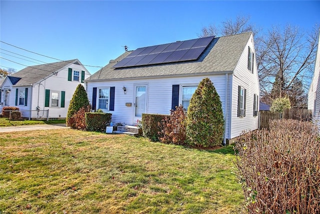 view of front of property featuring solar panels and a front lawn