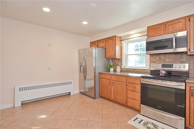 kitchen with decorative backsplash, appliances with stainless steel finishes, radiator, and light tile patterned flooring