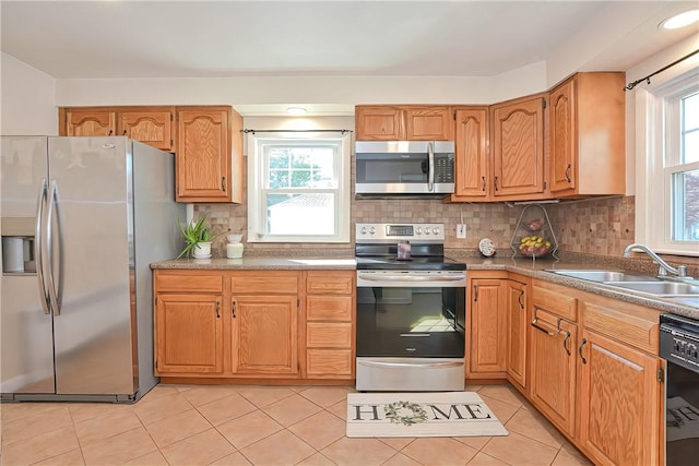 kitchen featuring appliances with stainless steel finishes, backsplash, a wealth of natural light, and sink