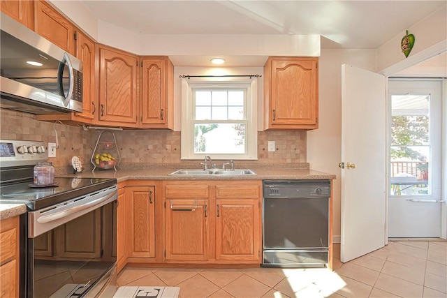 kitchen with light tile patterned flooring, sink, appliances with stainless steel finishes, and tasteful backsplash